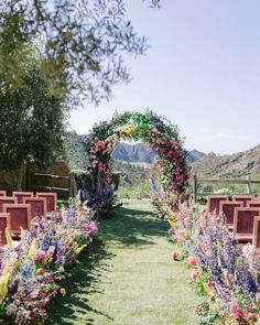 an outdoor ceremony setup with flowers and greenery