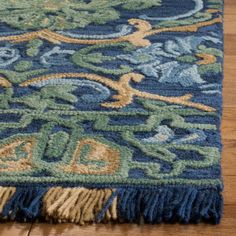 a blue and green rug with fringes on the floor