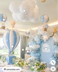 a table with balloons, flowers and other decorations on it in the shape of hot air balloons