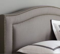 an upholstered headboard with beading and pillows