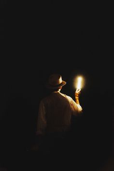 a person holding a lit candle in the dark