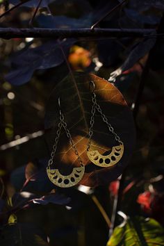 These handcrafted phases of the moon earrings have been inspired into creation by my love for and connection with the moon and her cyclical phases.  Solid raw brass arcs with the phases of the  moon cut out in them dangle from textured solid sterling silver chains and ear hooks.  I can make these earrings with either a regular ear hook or 16g hand hammered hoop ring that works well for stretched ears. See last pictures for stretched ear hoops and examples of the earrings with the stretched hoop Unique Gold Moon Phase Earrings, Celestial Moon Phase Moon Earrings, Mystical Gold Moon Phase Earrings, Bohemian Moon Shaped Brass Jewelry, Handmade Celestial Earrings For Festivals, Festival Moon-shaped Brass Earrings, Festival Moon Phase Brass Earrings, Unique Sun And Moon Design Dangle Earrings, Unique Sun And Moon Dangle Earrings