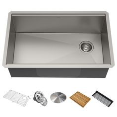 stainless steel kitchen sink with accessories including strainer, grater and cutting board on white background