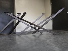 two metal sculptures sitting on top of each other in front of a wall with black doors