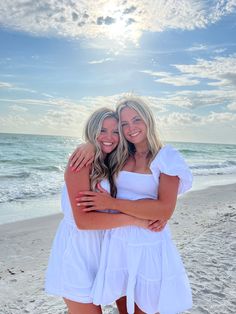 two women hugging each other on the beach