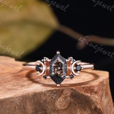 a close up of a ring on top of a piece of wood with leaves in the background