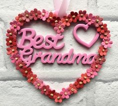 a heart shaped decoration with the words best grandma in pink and red flowers on it