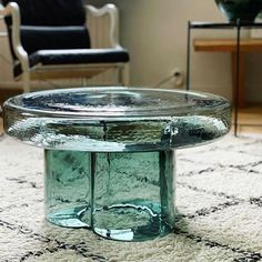 a glass coffee table sitting on top of a rug