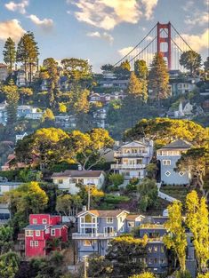 the golden gate bridge in san francisco is seen from across the valley, with houses on the hillside below