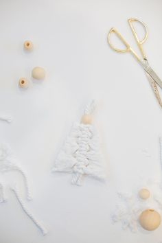 a pair of scissors next to some crocheted christmas trees and balls on a white surface