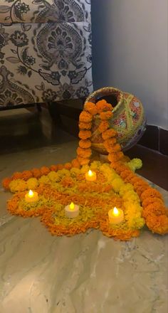 an arrangement of flowers and candles on the ground