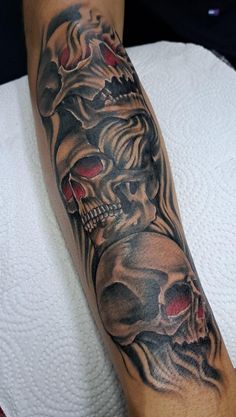 a man's arm with skulls and red eyes on the left side of his leg