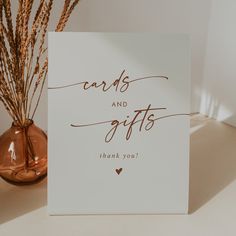 a card with the words cards and gifts written on it next to a vase filled with dry grass