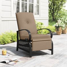 a reclining chair sitting on top of a patio next to a potted plant