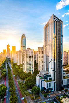 an aerial view of a city with skyscrapers and cars in the foreground at sunset