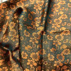 an image of a flowery fabric with gold flowers on blue and brown background,