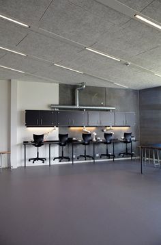 an empty room with several chairs and tables in front of the stove top ovens