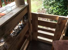 an outdoor kitchen with pots and pans on the counter top, next to a wooden deck