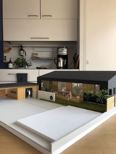 a model of a house in the middle of a kitchen with an open floor plan