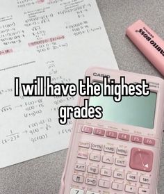 a pink calculator sitting on top of a table next to a pen and paper