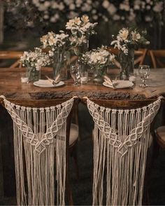 the table is set with two vases and some flowers on top of each other