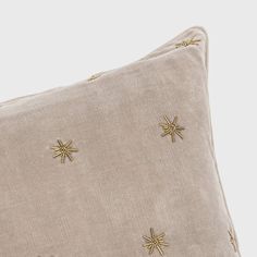 a beige pillow with gold stars on it