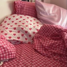 an unmade bed with orange and white checkered sheets