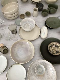 a table topped with lots of different types of plates and bowls next to each other