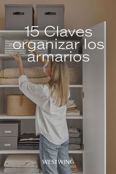 a woman standing in front of a closet filled with linens and other items that are on shelves