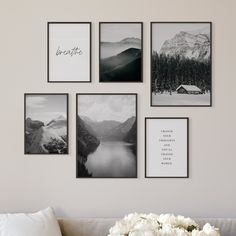 black and white photographs hang on the wall above a couch with flowers in front of it