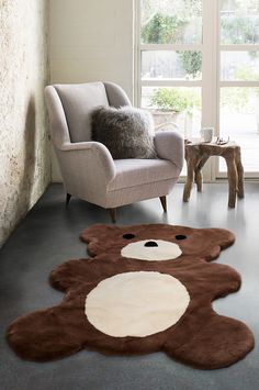 a teddy bear rug is on the floor next to a chair