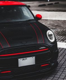 a small black and red car parked on the street