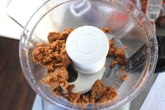 a food processor filled with cereal on top of a table