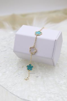 This bracelet features a pendant designed as a five-leaf flower, where one petal is crafted from lustrous mother of pearl and the other a vibrate turquoise stone. The combination of the iridescent mother of pearl and the vivid turquoise creates a stunning visual contrast, making the bracelet a standout piece for both casual and formal occasions. Length: 7” adjustable Clover: 14.4 mm Closure: Lobster Claw Material: Brass with 18K Gold Plating and Rhodium Coating Lead Free and Hypoallergenic Elegant Turquoise Flower Pendant Jewelry, Turquoise Jewelry With Flower Charm As Gift, Turquoise Jewelry With Flower Charm For Gift, Turquoise Flower Charm Pendant Jewelry, Elegant Turquoise Jewelry With Mother Of Pearl, Turquoise Flower-shaped Jewelry Gift, Elegant Turquoise Mother Of Pearl Jewelry, Turquoise Jewelry With Flower Charm, Elegant Green Bracelet With Flower Charm