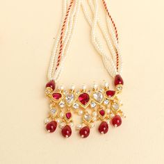 This unique Tanmani features 5 white-colored stones, complemented by pearls woven into the necklace strings. Red drop shape beads add a charming touch, enhancing the beauty of this exquisite design. Inspired by the Peshwa style, this necklace is a popular choice among women in Maharashtra. Crafted with 3mm pearls strings intricately woven and decorated with Jeri, the necklace comes with an adjustable thread. Please note that this is our handmade creation. You may also consider pairing it with our best-selling pearl earrings (kudi). This ethnic necklace is made by my DAD.  Length - 17 inches with adjustable thread. Pearl Studs that goes well with this design: https://zivarcreations.etsy.com/listing/661244418 Festive Adjustable White Necklace, Traditional Adjustable White Kundan Necklace, Red Pearl Temple Jewelry Necklace For Festivals, Red Pearl Necklace Temple Jewelry For Festivals, Red Temple Jewelry Pearl Necklace For Festivals, White Bridal Necklace For Festive Rituals, White Kundan Necklace For Rituals, Traditional Red Beaded Pearl Necklace, Adjustable Red Pearl Necklace