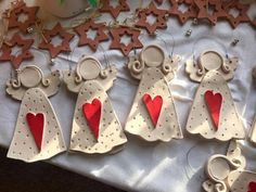 christmas ornaments made to look like angels with red hearts on them and stars in the background