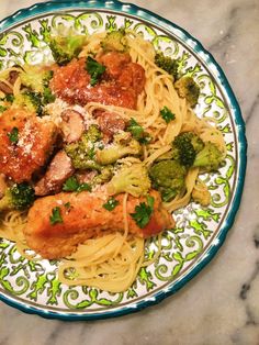 pasta with meat, broccoli and sauce in a bowl on a marble table