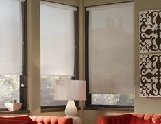 a living room with two red couches and three white lamps on the side of the wall