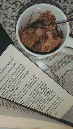 an open book sitting on top of a table next to a bowl filled with food