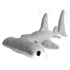 two crocheted shark pillows sitting next to each other on a white table top