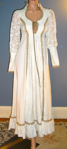 "Vintage 70s Gunne Sax boho, medieval, renaissance or possibly wedding dress. Size 5. Sleeves have zippers at the wrists. Model is too big to zip up the dress but the zipper works fine. The poplin material is 50% cotton 50% poly. Lace is 100\" cotton as is the trim. The dress is hand washable. Perfect condition, no flaws. Measurements: Shoulders across front: 13\" Chest across front: 15\" Waist across front: 12\" Length from waist: 42\" Sleeve length from shoulder: 26\" Please read all measureme White Medieval Wedding Dress With Historical Design, White Vintage Victorian Dress For Fancy Dress, White Victorian Dress For Fancy Dress, Medieval Style White Wedding Dress, Vintage Long Sleeve Medieval Dress For Fancy Dress, Vintage Floor-length Medieval Dress For Fancy Dress, White Medieval Dress With Historical Design, White Historical Design Gown For Costume, White Long Sleeve Costume Gown