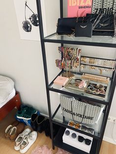 a rack with many different types of bracelets and purses on it next to a bed