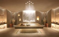 a large spa room with candles lit up on the walls and lights in the ceiling