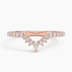 a rose gold wedding band with two pear shaped diamonds on the top and bottom, set in