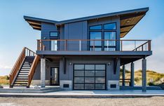 a two story house with stairs leading up to the second floor and an attached balcony