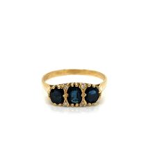 Vintage 14k yellow gold Victorian Reproduction 3 Stone Oval Sapphire and Diamond Statement Ring. The center sapphire measures about 6 x 4mm and the 2 side sapphires measure about 5 x 4mm. The sapphires weigh approximately 1.33ct total weight and they have a deep navy blue color. There are 4 round single cut diamonds accented on the top between the sapphires and they about .04ct total. There is beautiful filigree workmanship under the the sapphires. The height of the ring off the finger is 3.8mm Classic Gold Three-stone Sapphire Ring, Timeless Oval Sapphire Ring Stamped 14k, Classic Gold Three Stone Sapphire Ring, Timeless 14k Stamped Oval Sapphire Ring, Classic Gold Sapphire Ring With Three Stones, Gold Oval Three Stone Rings, Gold Three Stone Oval Rings, Gold Oval Sapphire Birthstone Ring, Gold Sapphire Birthstone Ring, Oval Shape