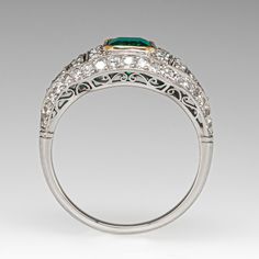 This gorgeous ring is centered with an emerald cut emerald, weighing 1.00 carat, in a yellow gold plated bezel. The top of the ring is bead set with fifty-eight (58) round single cut diamonds and accented with milgrain details. The ring measures 9.9mm at the top, rises 4.8mm above the finger, tapering to 1.7mm wide and 1.1mm thick at the base of the shank. It is currently a size 6.5. The emerald is unnoticeably chipped. Elegant Emerald Ring For Anniversary, Luxury Emerald Ring With Diamond Cut For Formal Occasions, Luxury Emerald Ring With Diamond Cut For Formal Events, Luxury Emerald Rings With Diamond Cut, Elegant Emerald Ring With Diamond Accents For Anniversary, Luxury Oval Emerald Ring With Diamond Cut, Elegant Emerald Gemstone Ring For Anniversary, Elegant Emerald Cut Platinum Jewelry, Elegant Formal Round Cut Emerald Ring