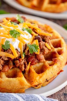 a waffle topped with chili cheese and sour cream