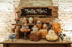 a table topped with lots of candy and candies next to a sign that says salty barrel