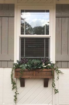 a window box with plants in it on the side of a house